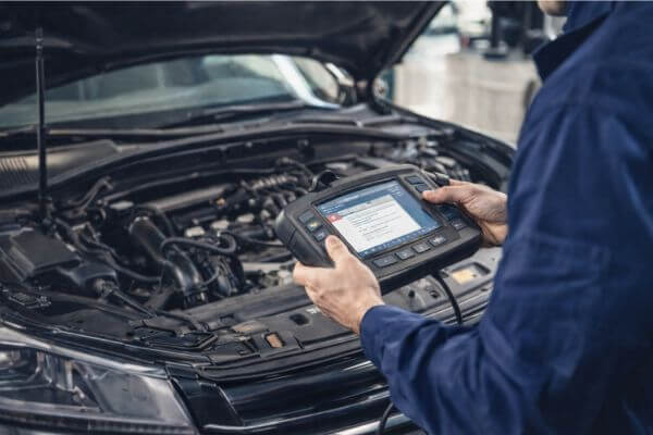 Mecânico usando scanner automotivo para diagnosticar carro falhando no motor