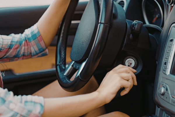motorista tentando dar partida no carro com a chave na ignição