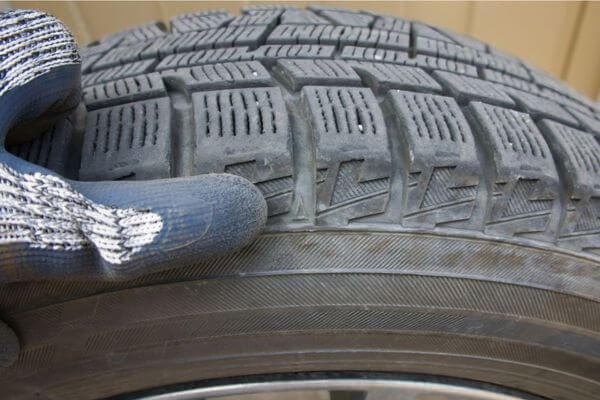 Pneu desgastado sendo inspecionado para verificar risco de multa de pneu careca